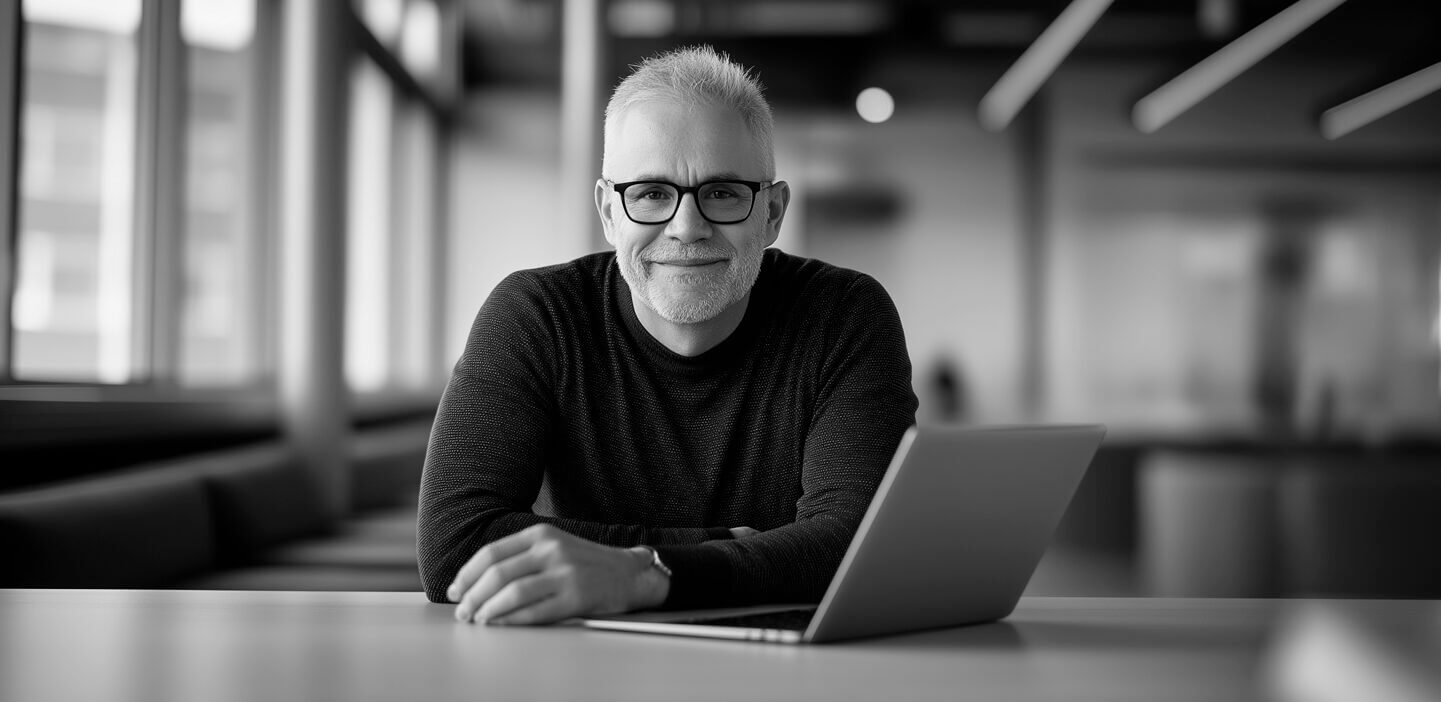 Smiling man sitting in front of his laptop