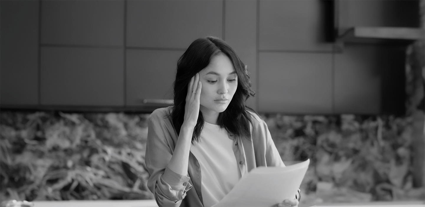 Woman seated at a desk, reviewing paperwork