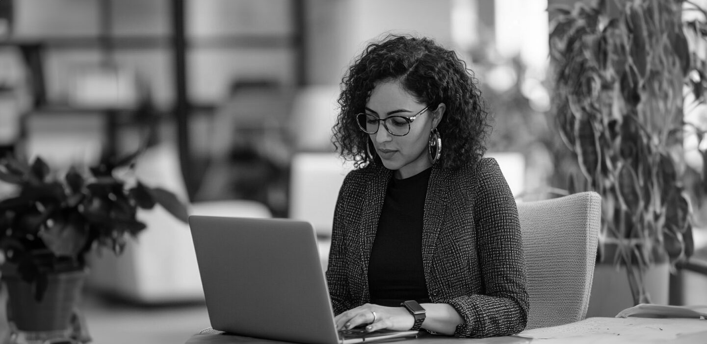 Woman looking down and typing on her laptop