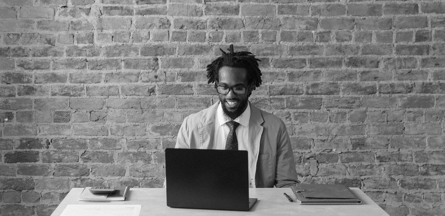 Man seated at his desk, typing on a computer